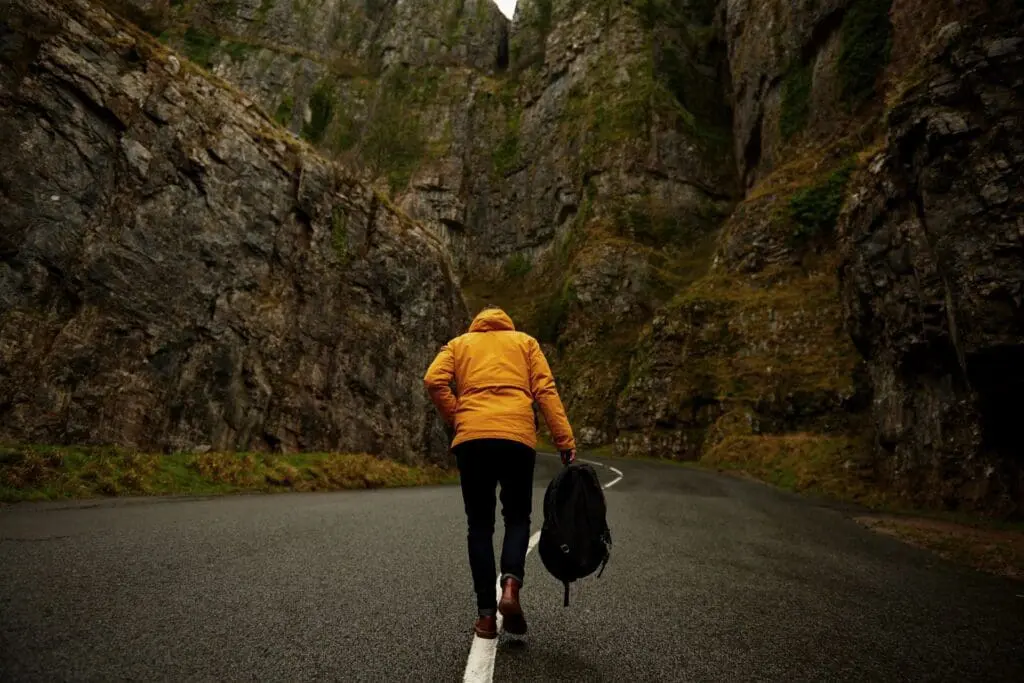Person walking in rocky canyon road.