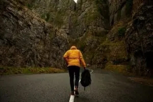 Person walking in rocky canyon road.