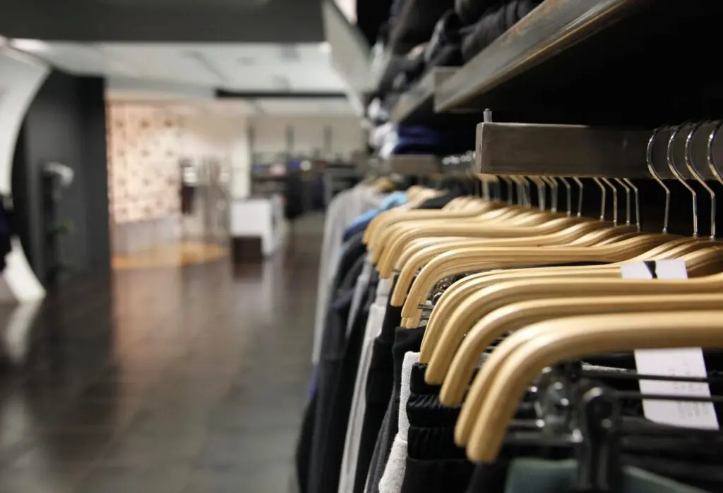 Clothing store with wooden hangers displayed.